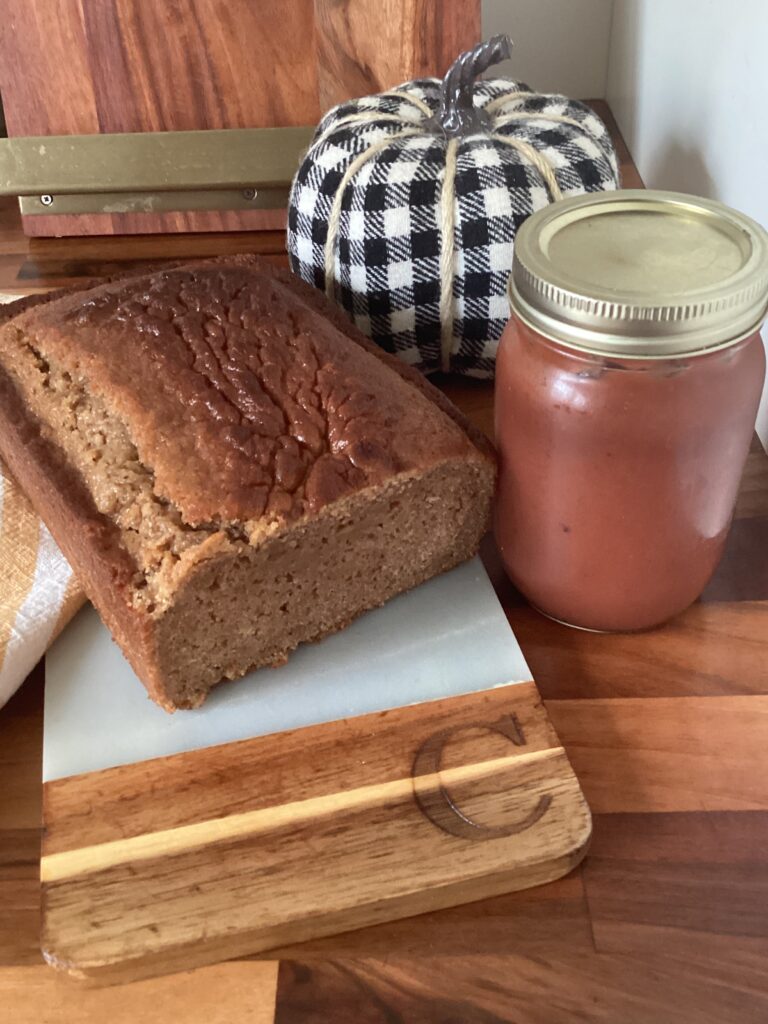 Apple butter bread on countertop beside a jar of apple butter